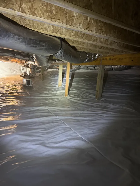 Crawl space after: new white vapor barrier and a clean floor